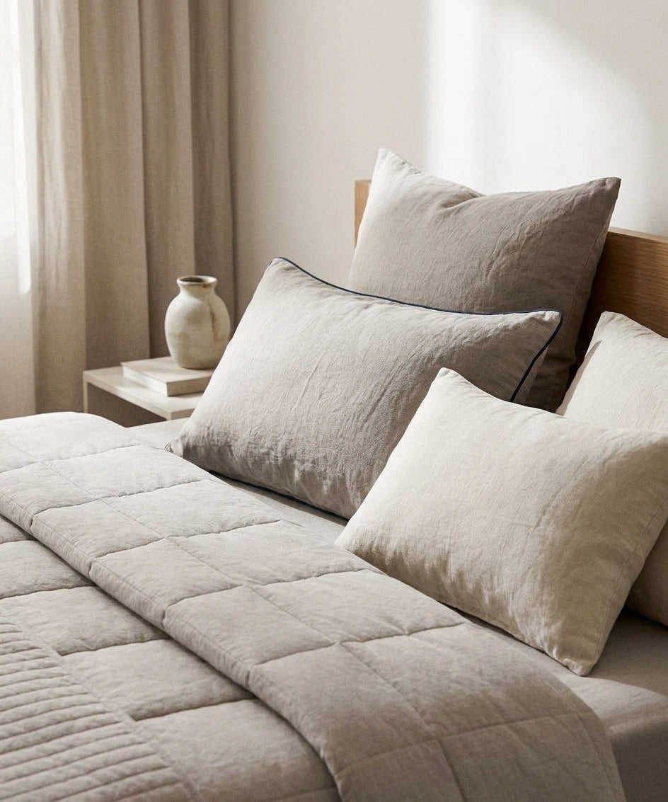 Three pillows of different heights for side, back, and stomach sleepers on a bed