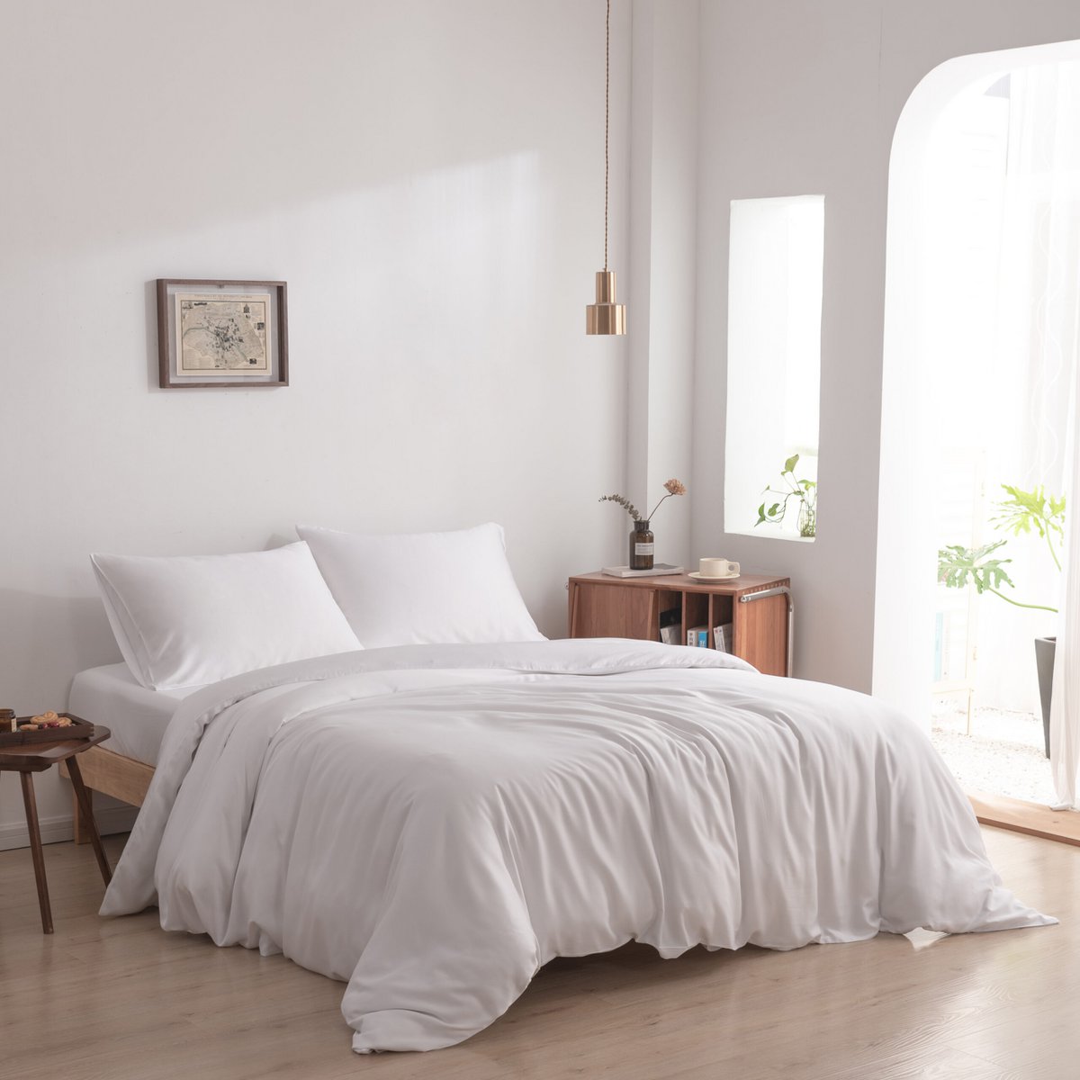 Coco White bamboo bedding set styled in a bedroom with a side table