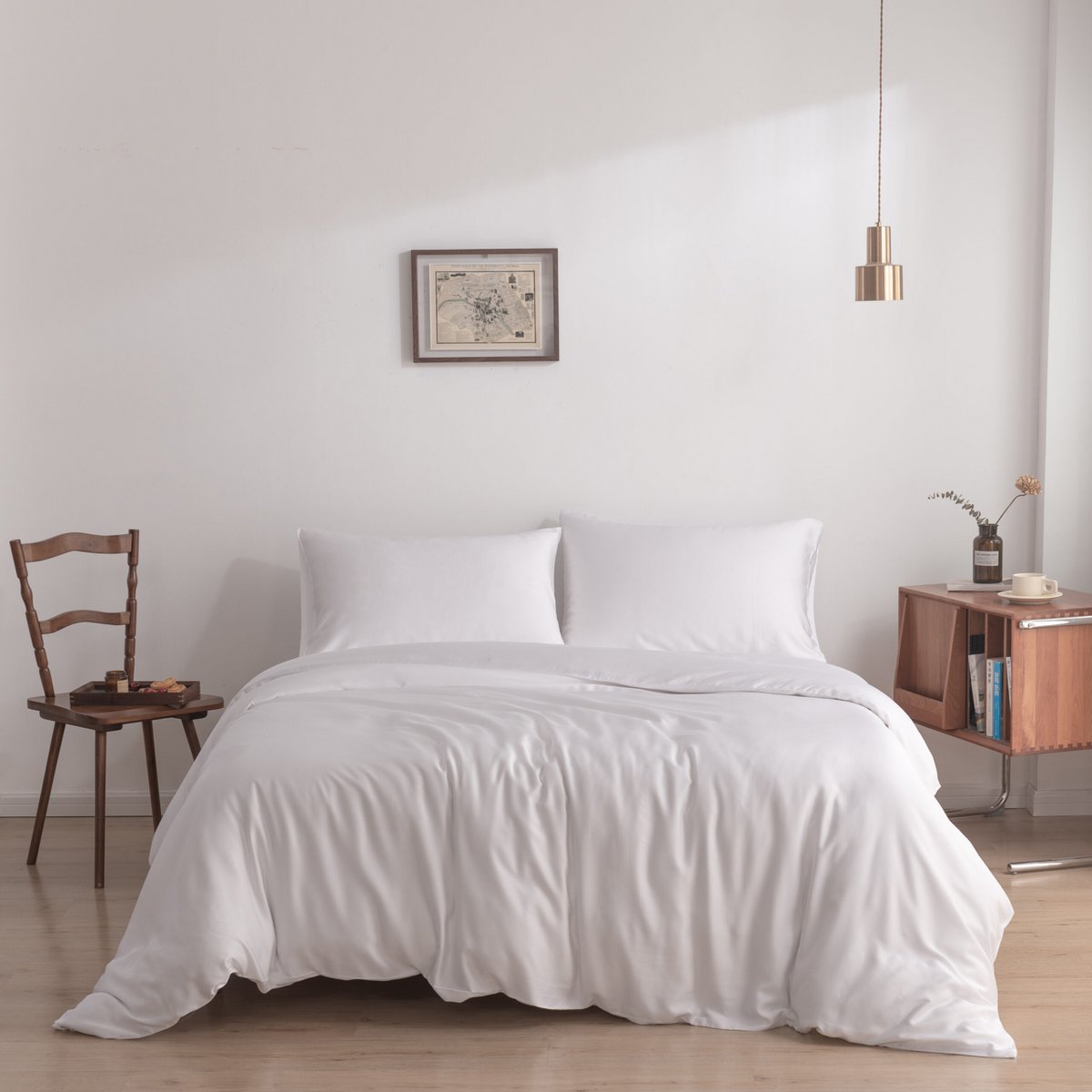 Coco White bamboo bedding set on a bed against a wall with framed art