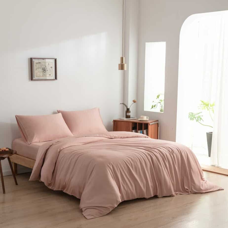 Cuddle Pink bamboo bedding set styled on a bed by a window