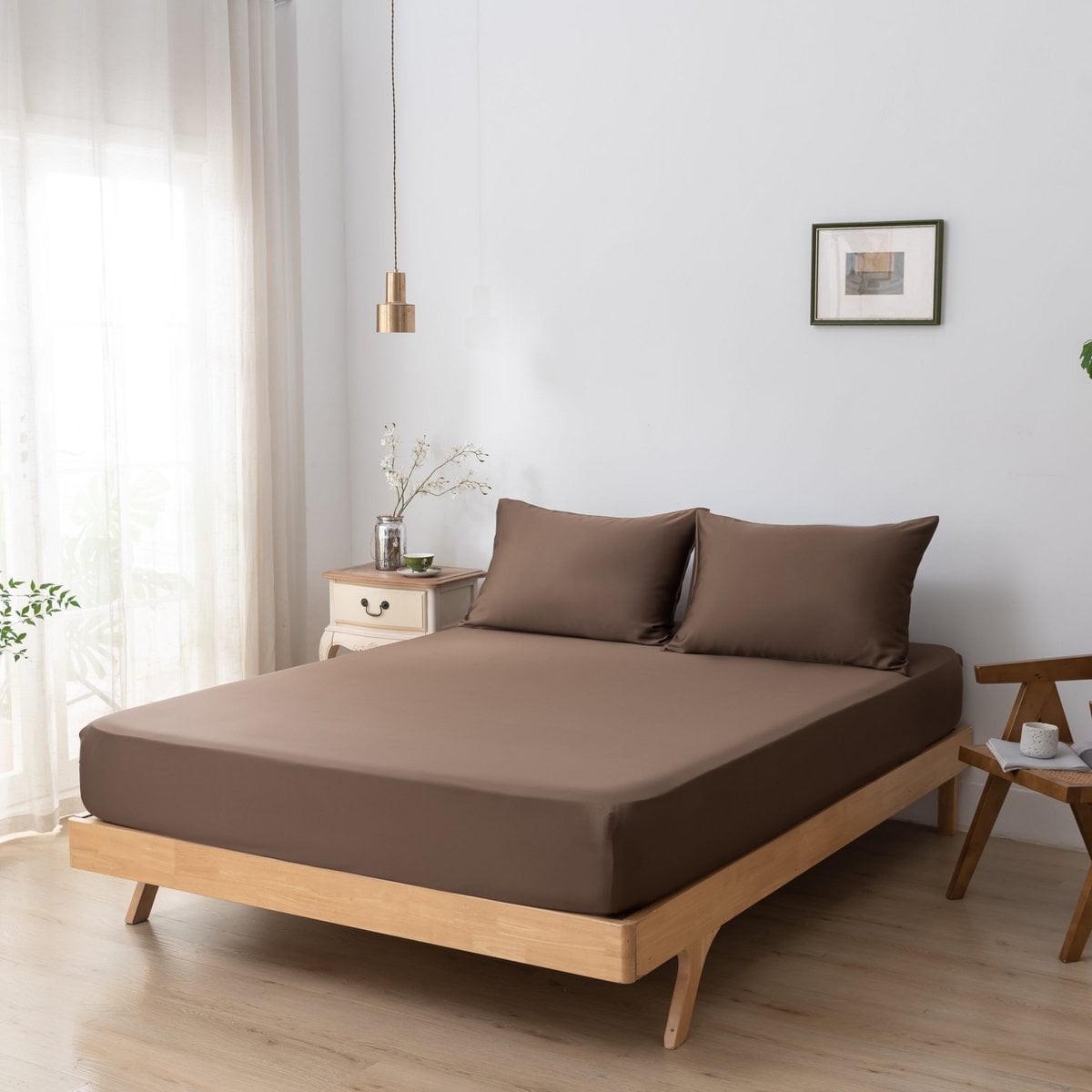 Coffee Brown bamboo fitted sheet styled on a wood-frame bed in a bright bedroom.