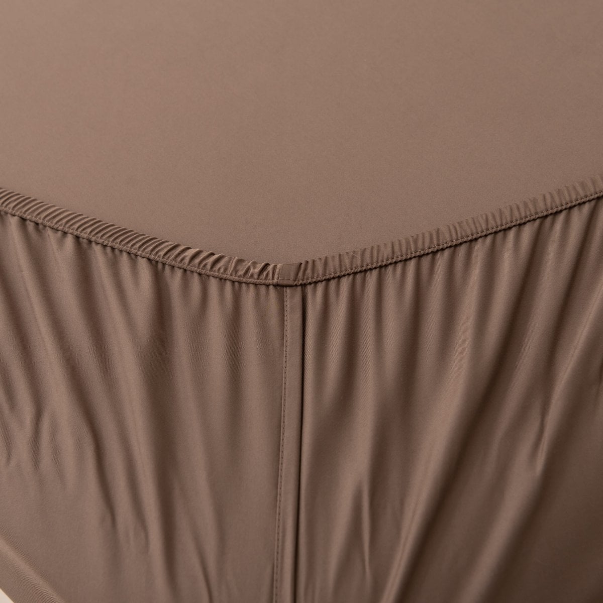 Close-up of the Coffee Brown bamboo fitted sheet's corner seam and elastic stitching.