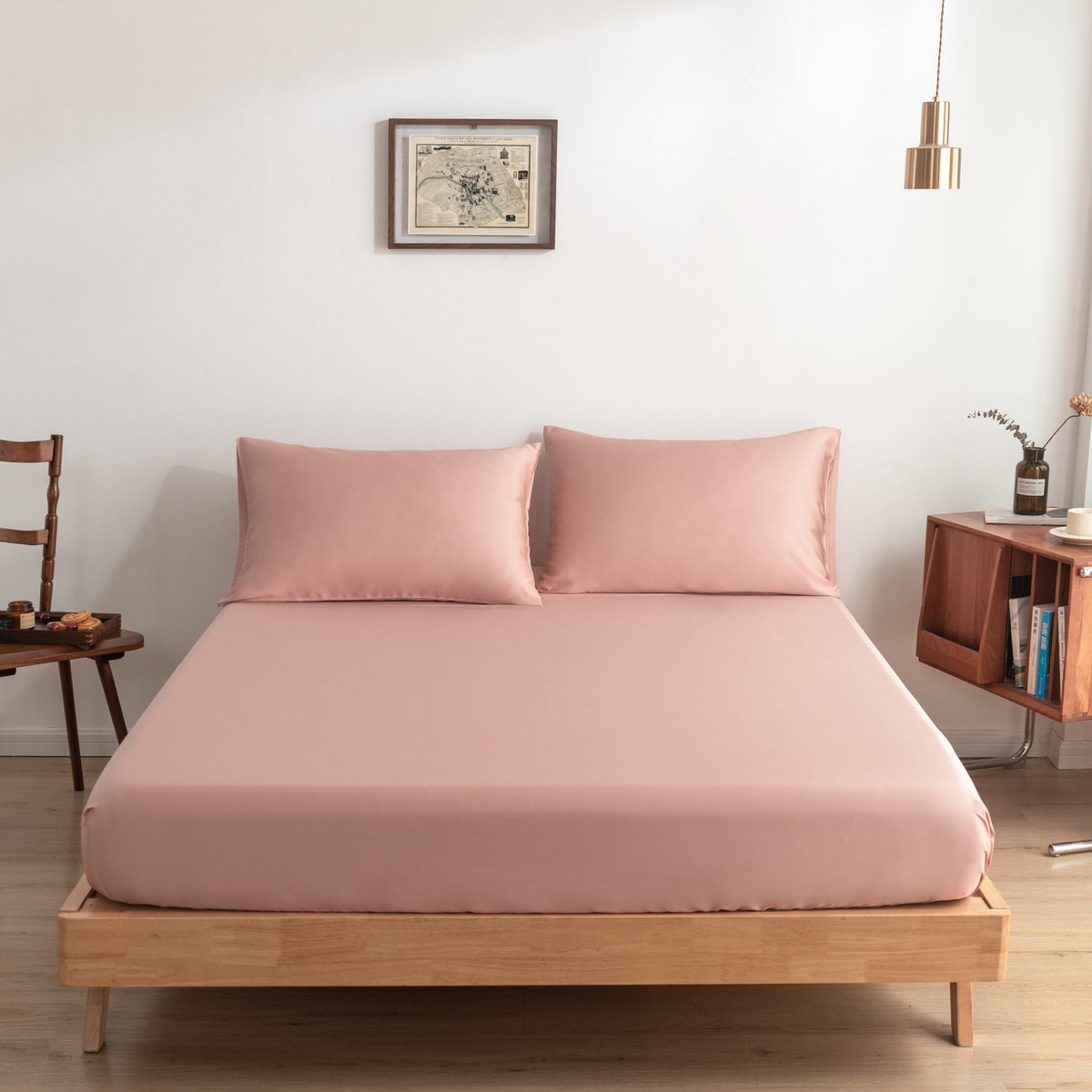 Cuddle Pink bamboo fitted sheet on a made bed, shown straight-on with two matching pillows.