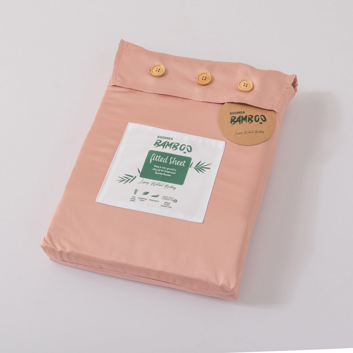 Cuddle Pink bamboo fitted sheet for mattress toppers folded and packaged with the Boomba Bamboo product label.