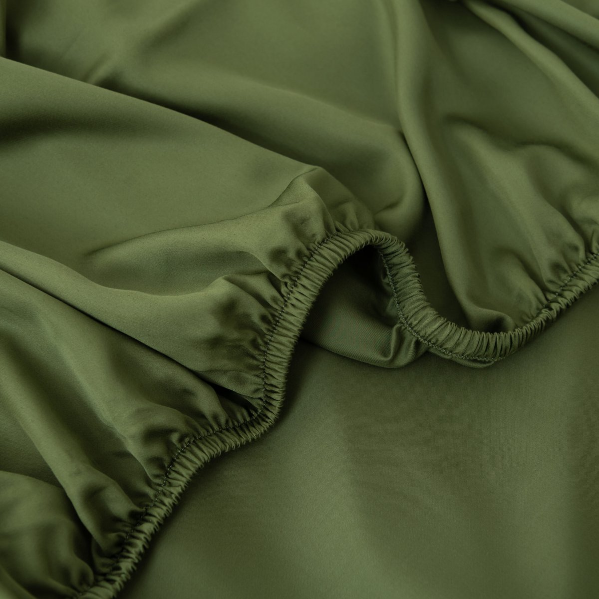 Close-up of the Deep Moss bamboo fitted sheet's folded elastic corner.