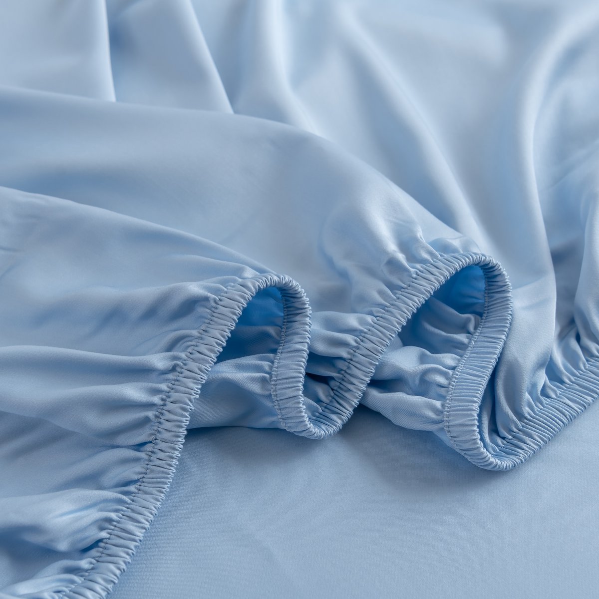 Close-up of the Sky Blue bamboo fitted sheet's folded elastic corner off the mattress.