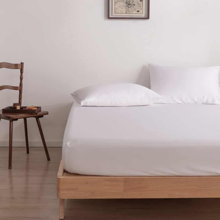 Coco White bamboo pillowcases on a wood-framed bed