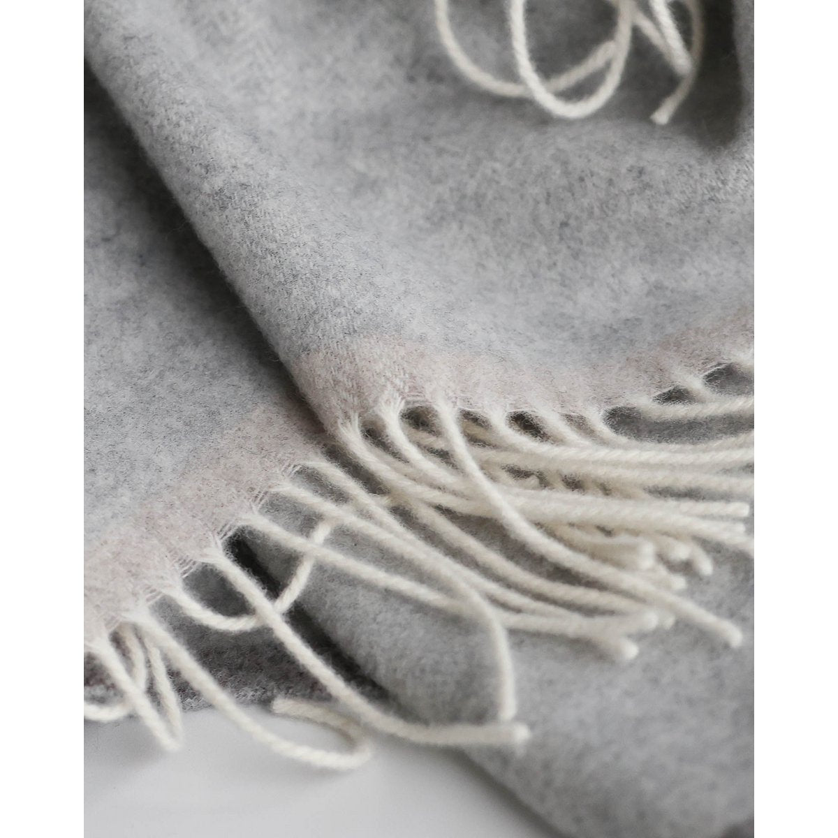 Close-up of Milano throw's soft cashmere-wool texture in light grey