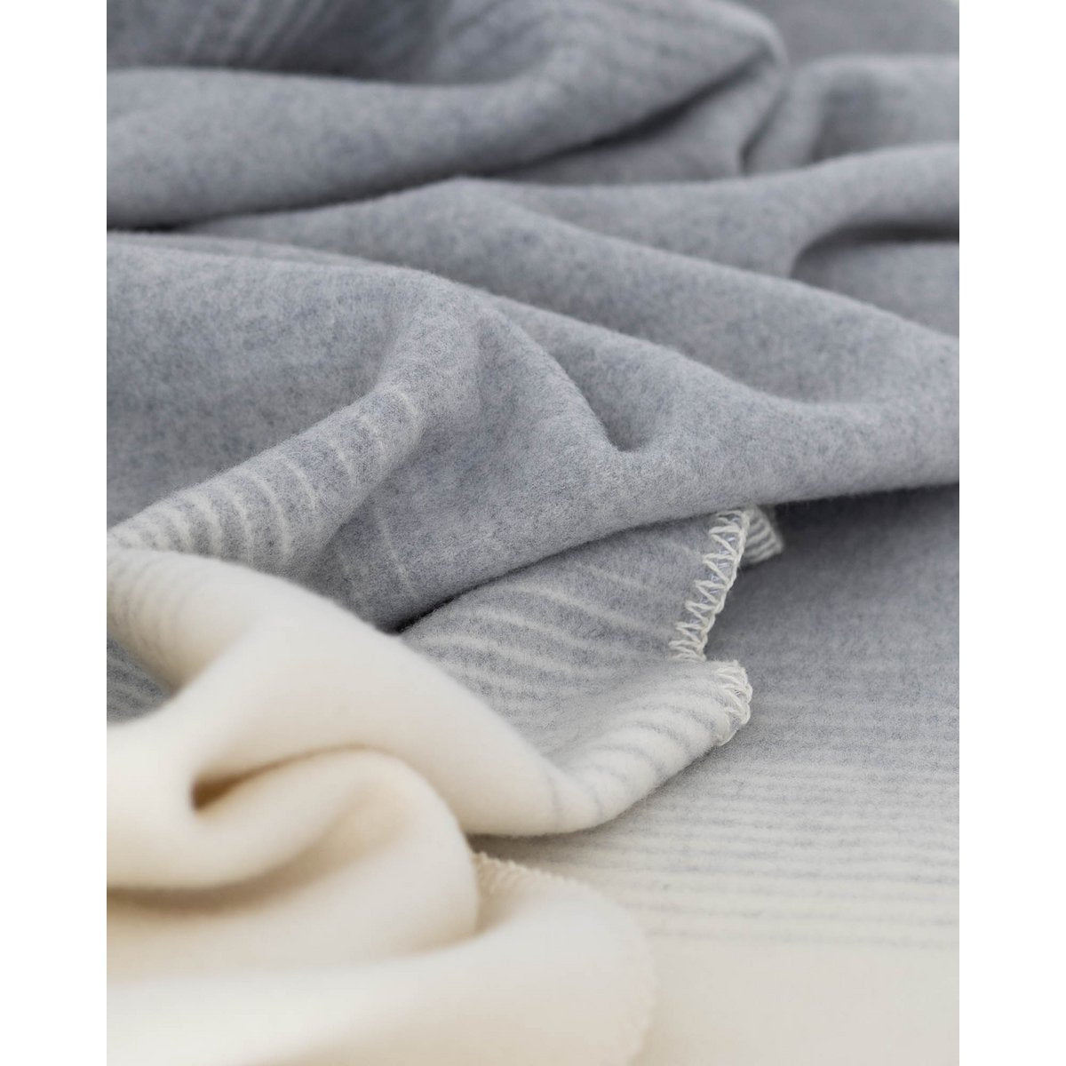 Merino & Cashmere Throw Blanket Silver Cloud styled on a bed