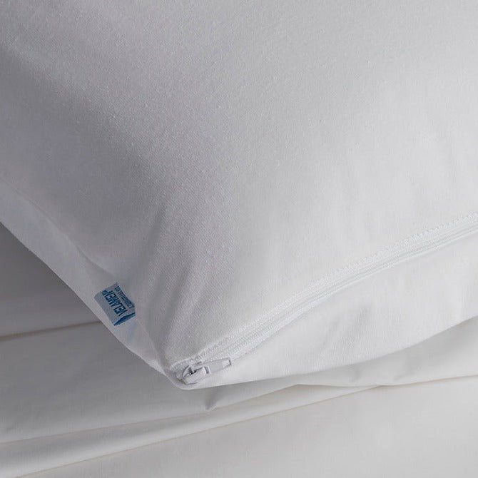 Close-up of the white organic cotton pillow protector corner showing the zipper closure and Velfont brand label