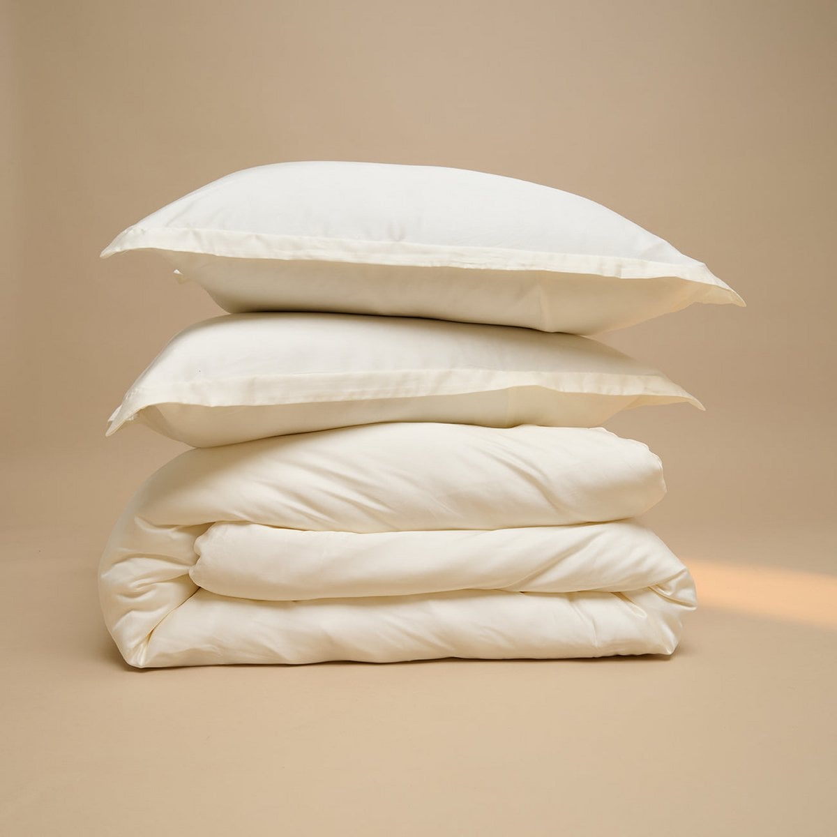 Tencel™ Sateen Duvet Cover in Off White folded and stacked with matching pillowcases
