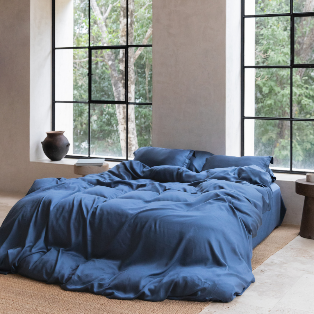 Tencel™ Twill Duvet Cover in Dark Blue styled on a bed by a window