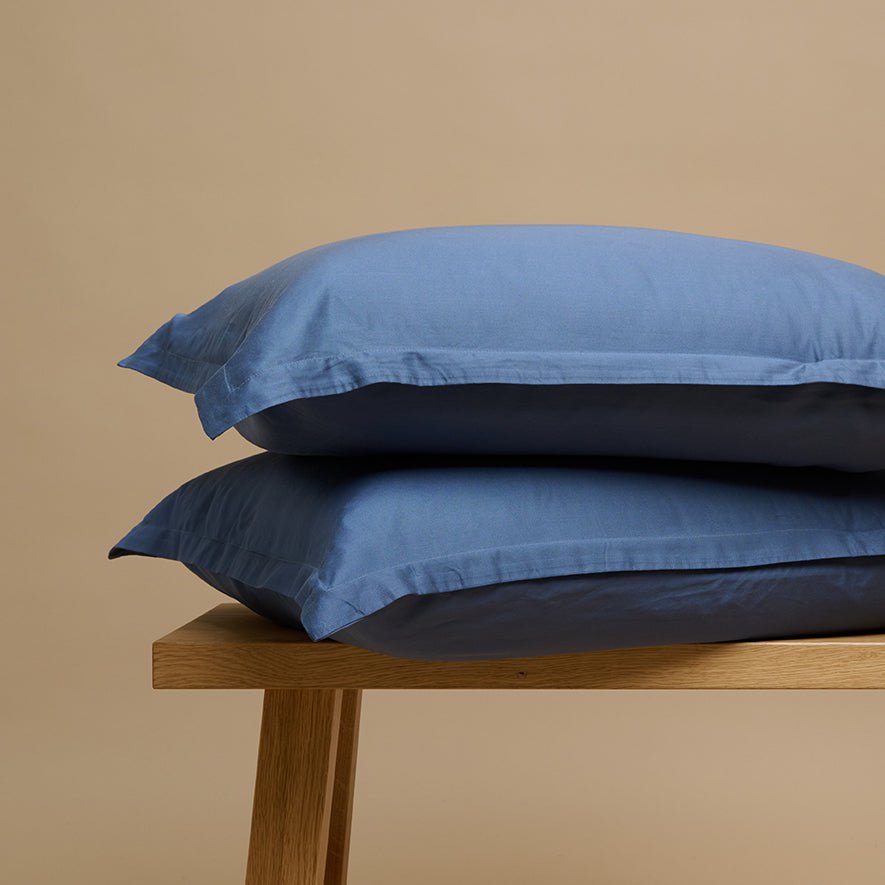 Tencel™ Twill Pillowcase in Dark Blue stacked on a wooden bench