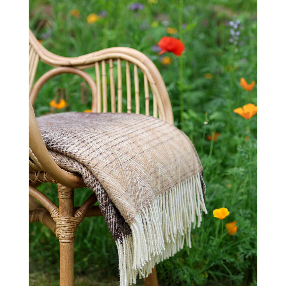 Manoria Savana throw styled in an outdoor garden setting
