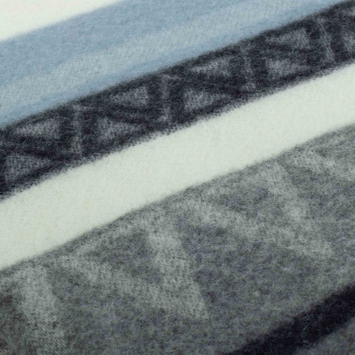 Wool Throw Blanket Triangel Blue draped over a sofa