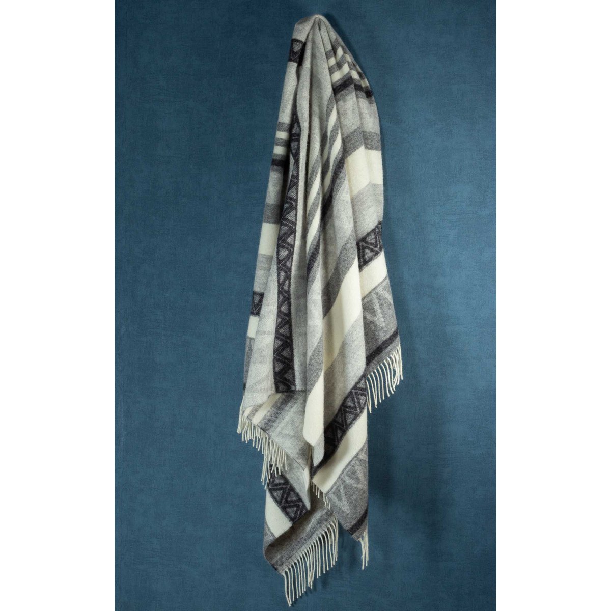 Wool Throw Blanket Triangel Grey draped over a sofa