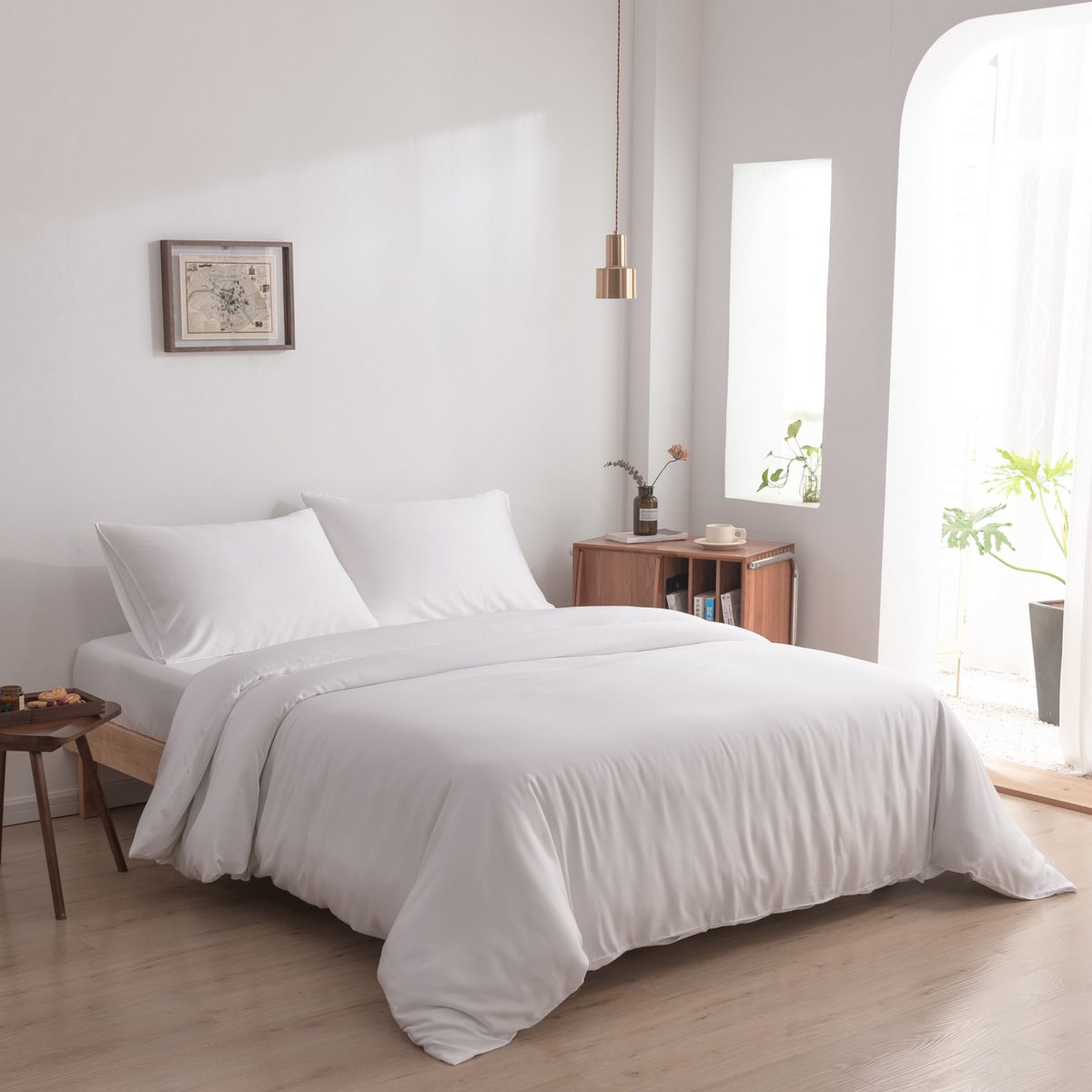Coco White bamboo bedding set styled on a bed by a bright window