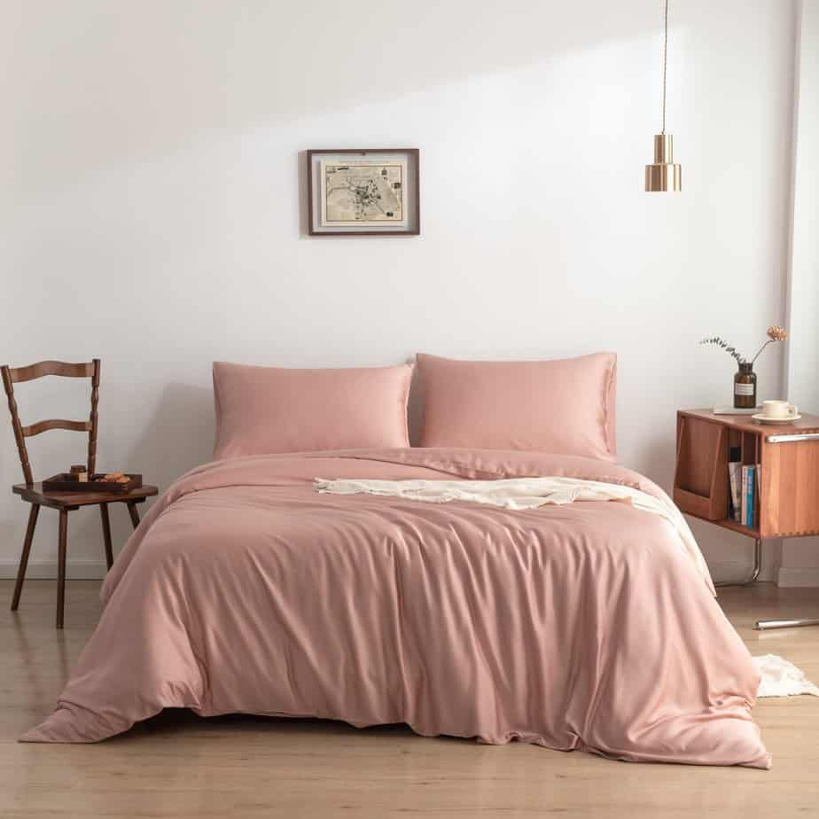 Cuddle Pink bamboo bedding set styled on a bed with a chair