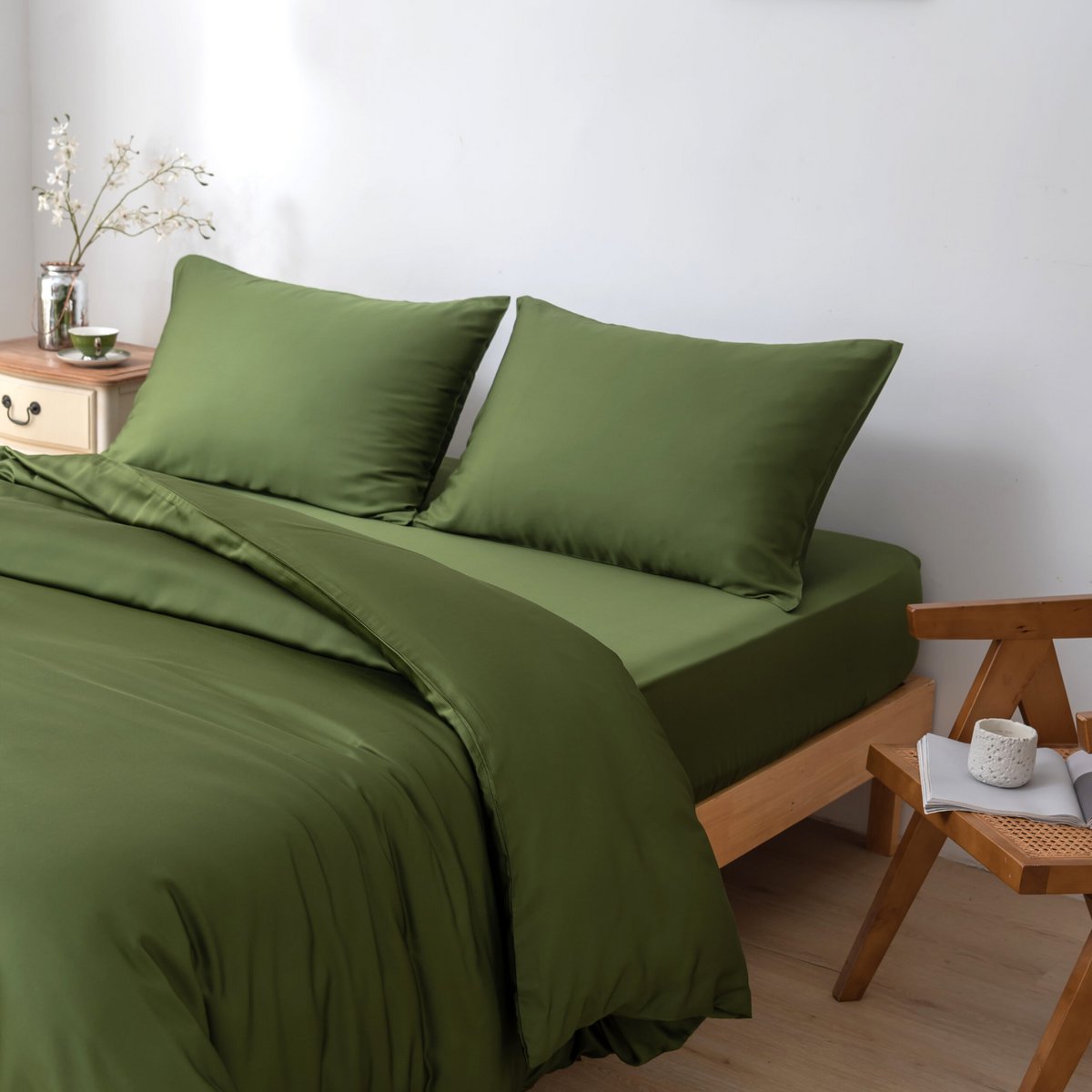 Deep Moss bamboo bedding set styled in a bedroom with a plant