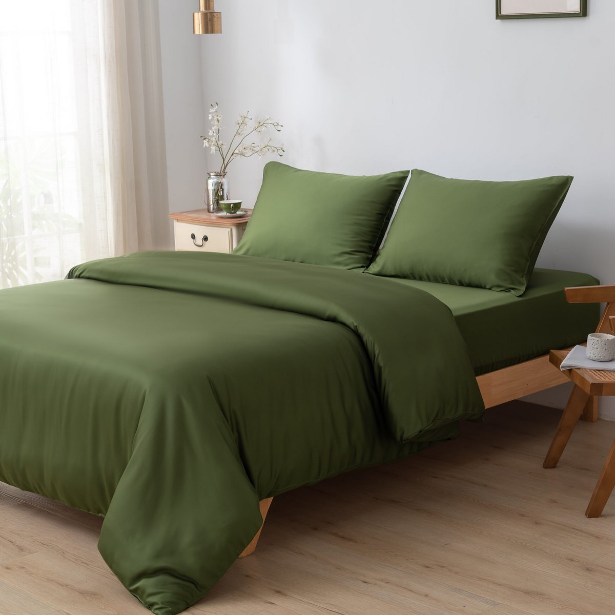 Deep Moss bamboo bedding set styled in a bedroom with a side table