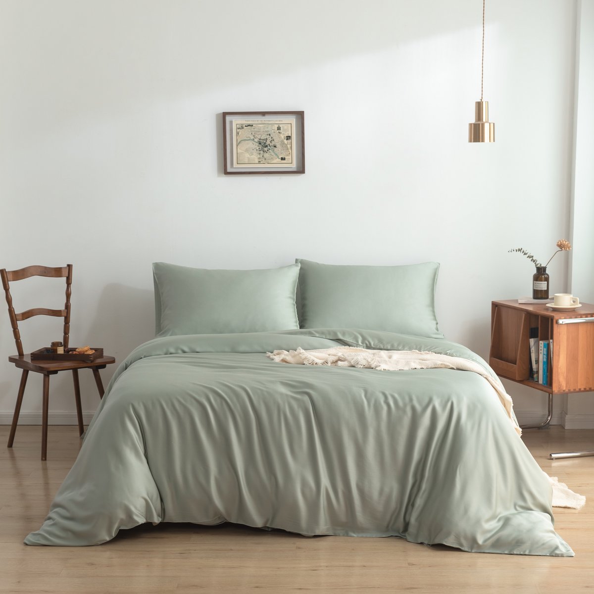 Sage Green bamboo bedding set on a bed against a wall with framed art