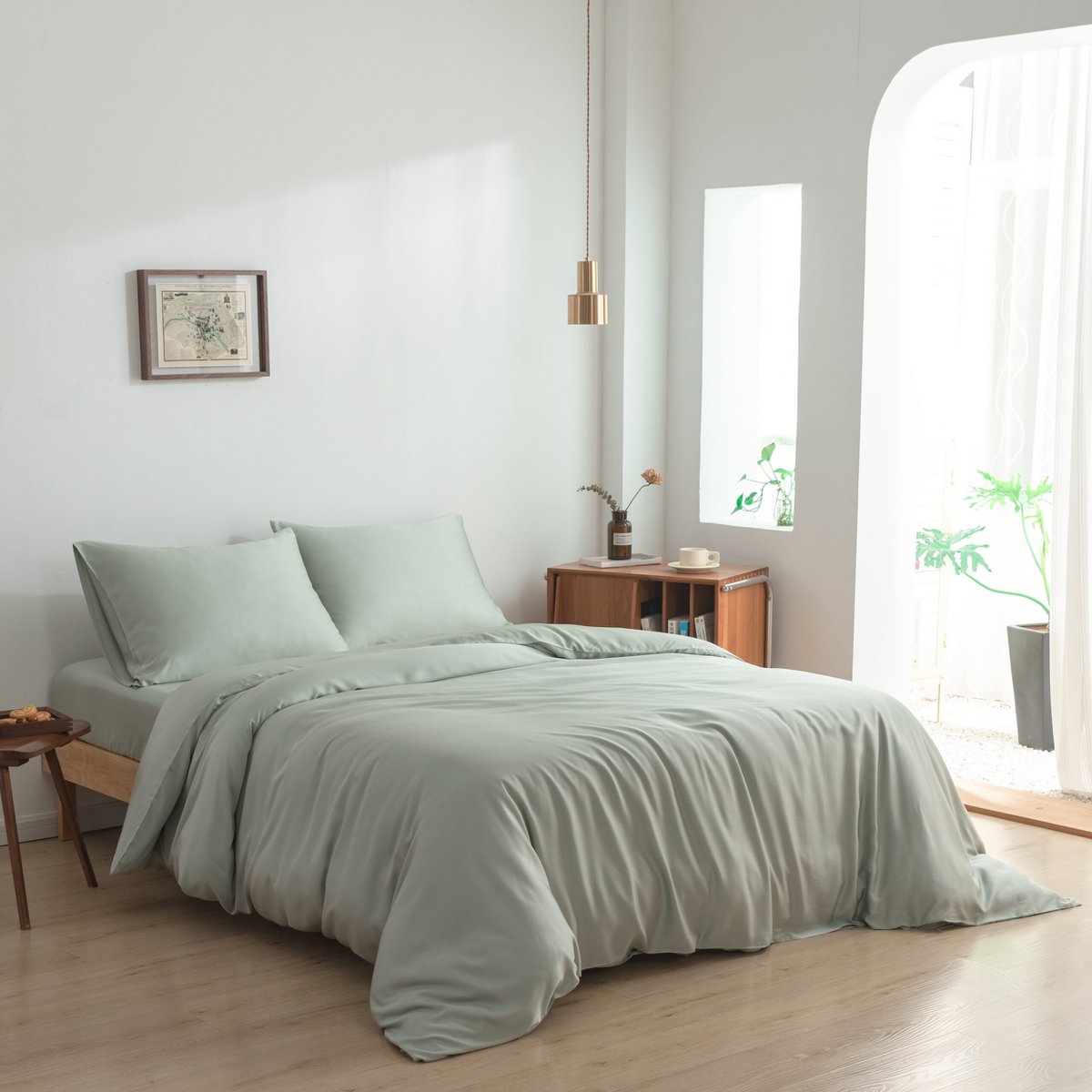Sage Green bamboo bedding set styled on a bed with a chair