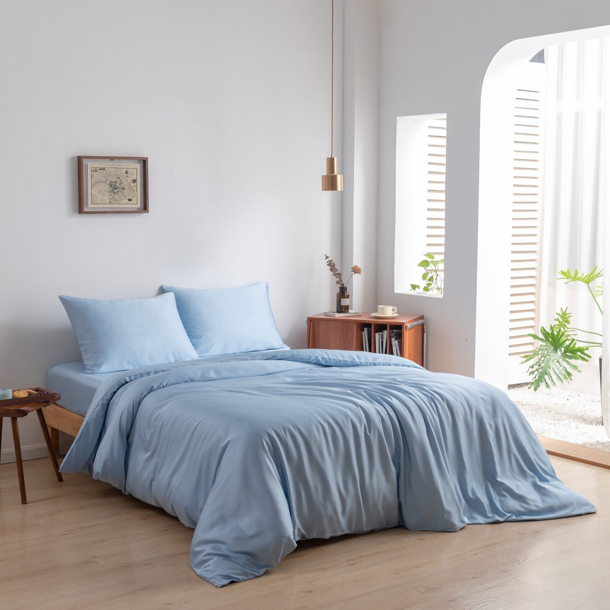 Sky Blue bamboo bedding set styled on a bed by a bright window