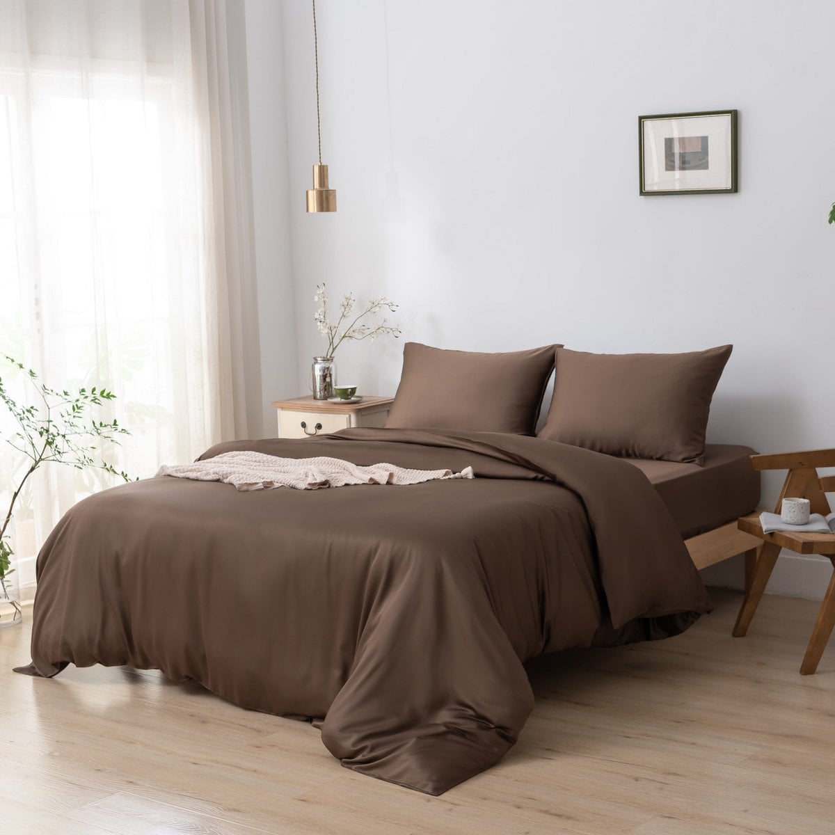 Bamboo duvet cover in Coffee Brown styled on a bed with a hanging pendant light and framed art