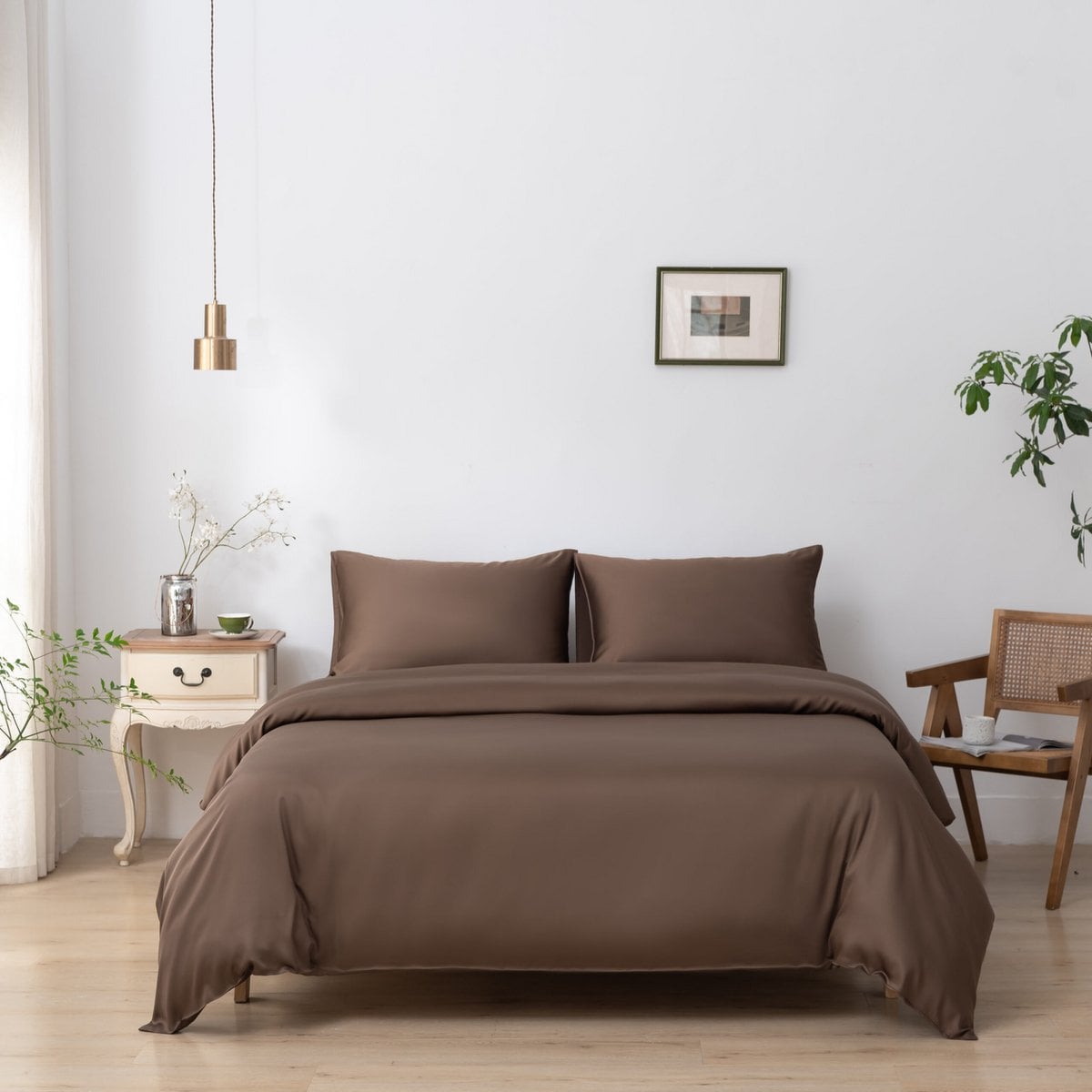 Bamboo duvet cover in Coffee Brown on a bed beside a wooden chair with a cup and book