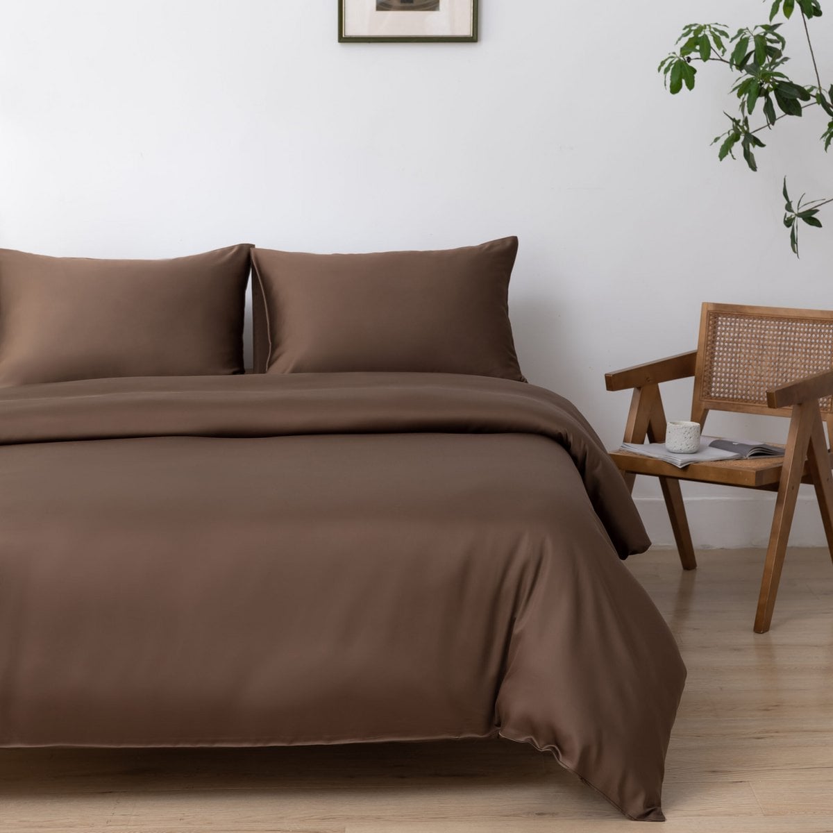 Bamboo duvet cover in Coffee Brown on a bed beside a cane chair and cream nightstand