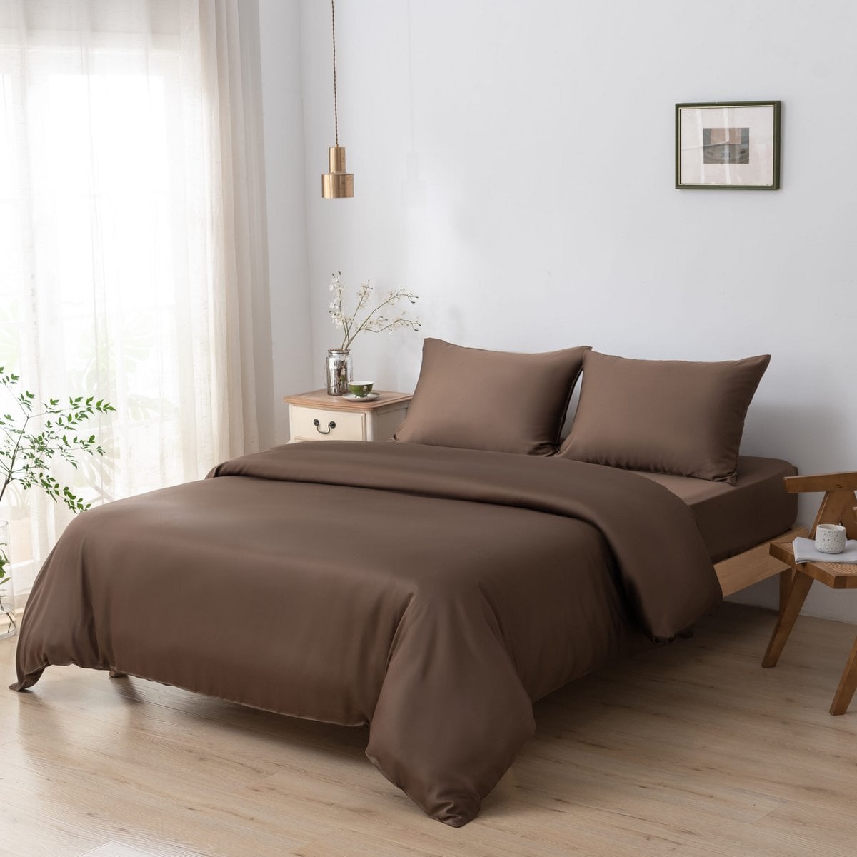 Bamboo duvet cover in Coffee Brown on a bed with a framed print and a wooden nightstand