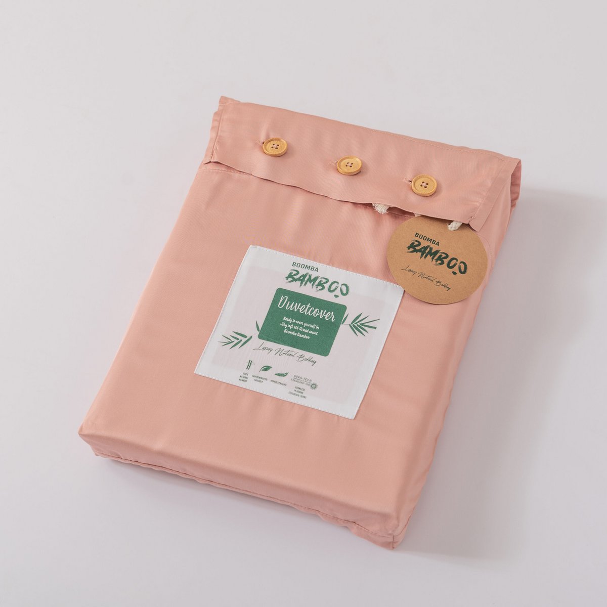 Folded Cuddle Pink bamboo duvet cover with bamboo buttons fastened and the Boomba Bamboo branded label and hang tag attached