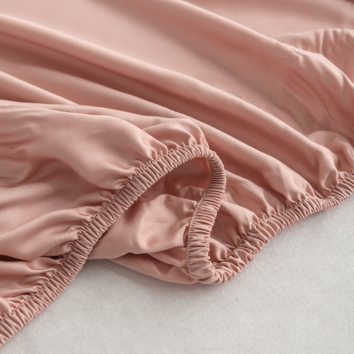 Close-up of the Cuddle Pink bamboo fitted sheet's folded elastic corner.