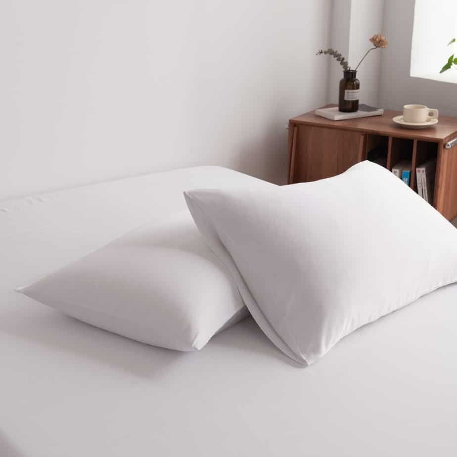 Coco White bamboo pillowcases styled on a chair