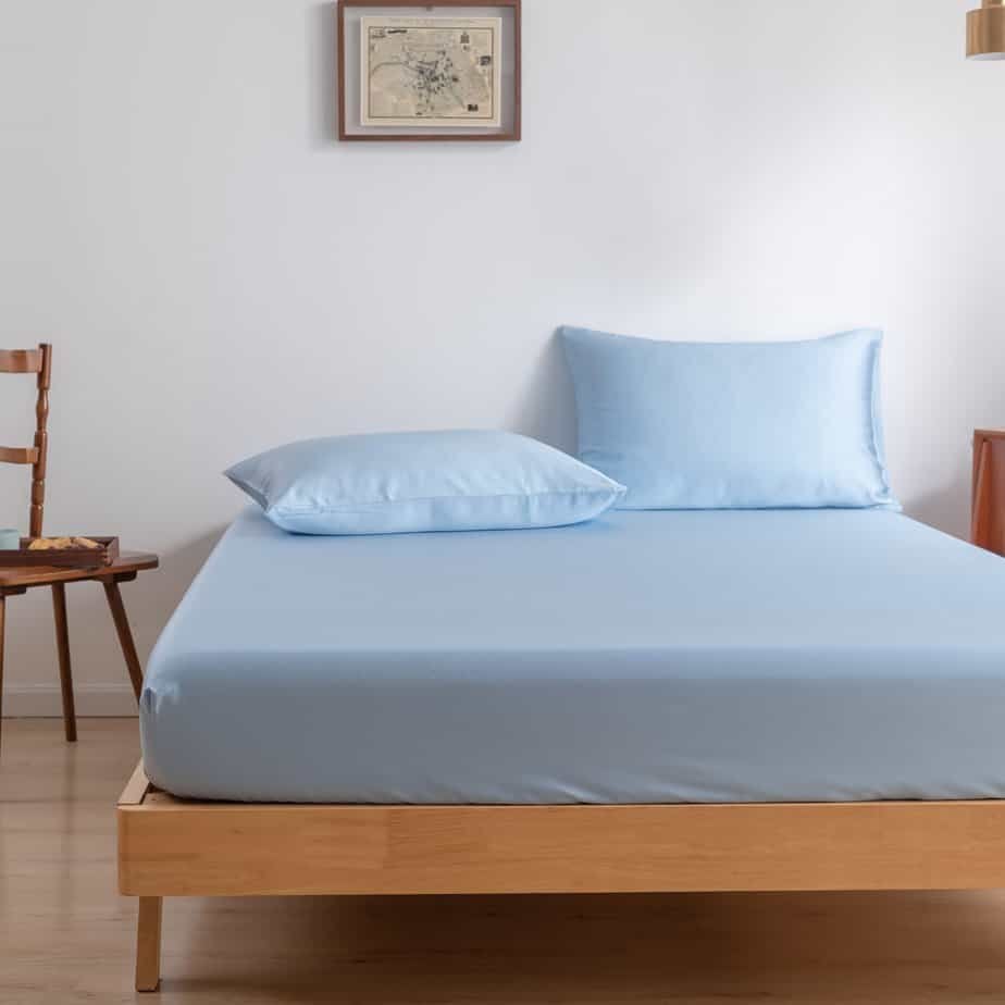 Sky Blue bamboo pillowcases on a wood-framed bed