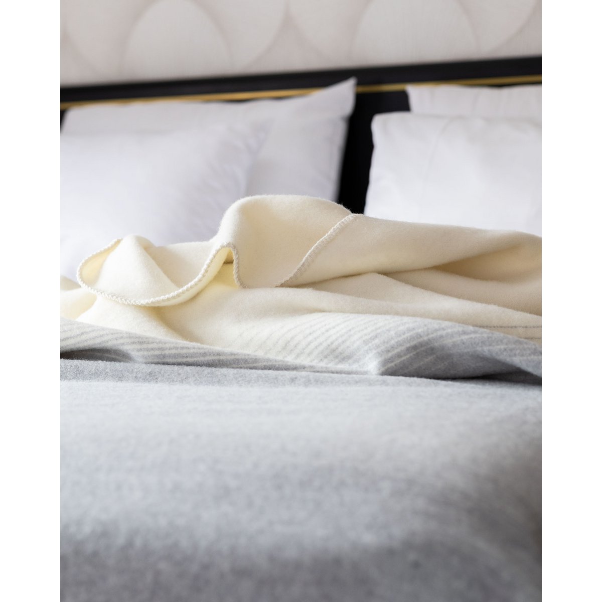 Ivory Mist bedspread draped over a bed with fringe detail visible