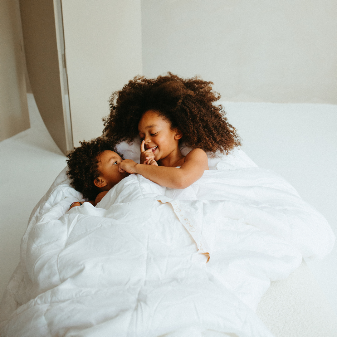 Children cuddled under the Tencel™ Four Seasons Duvet
