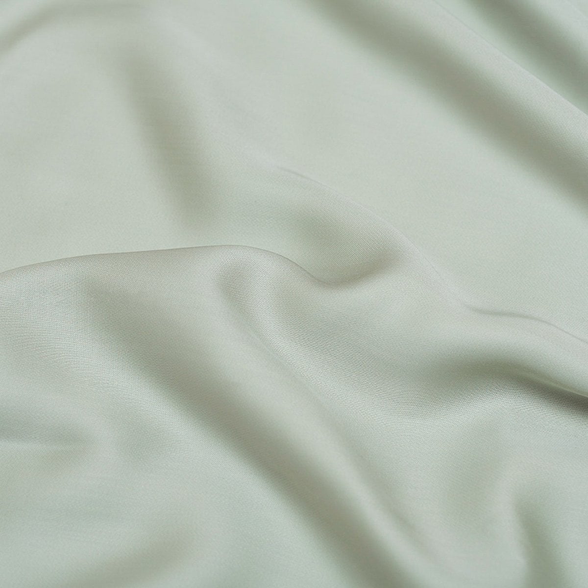 Close-up of the Tencel™ Sateen fabric draped, showing texture in Gray Green
