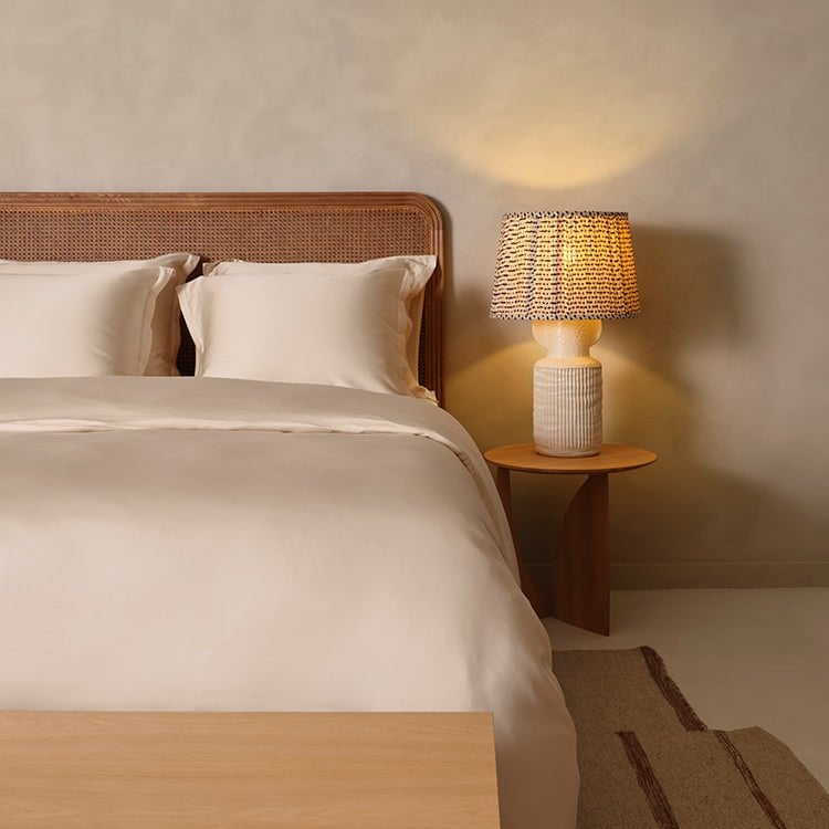 Tencel™ Sateen Duvet Cover in White Sand styled on a bed with warm lighting