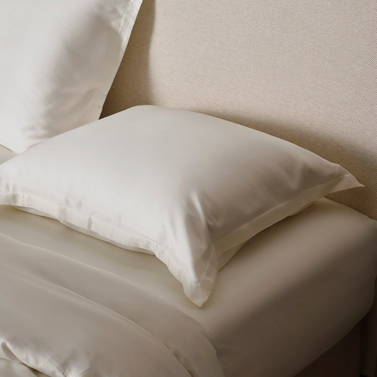 Folded Tencel Sateen pillowcase in off white showing fabric drape
