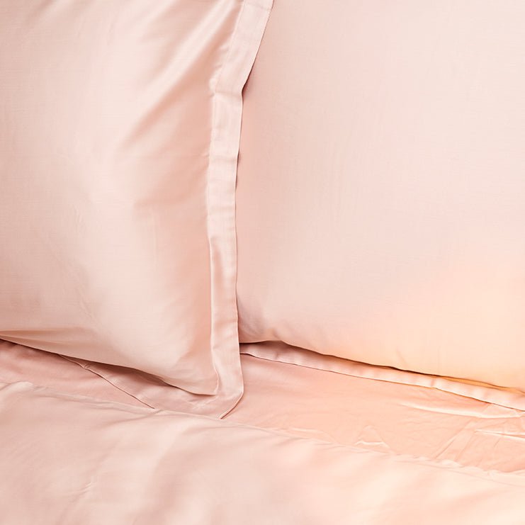 Folded Tencel Sateen pillowcase in peach white showing fabric drape