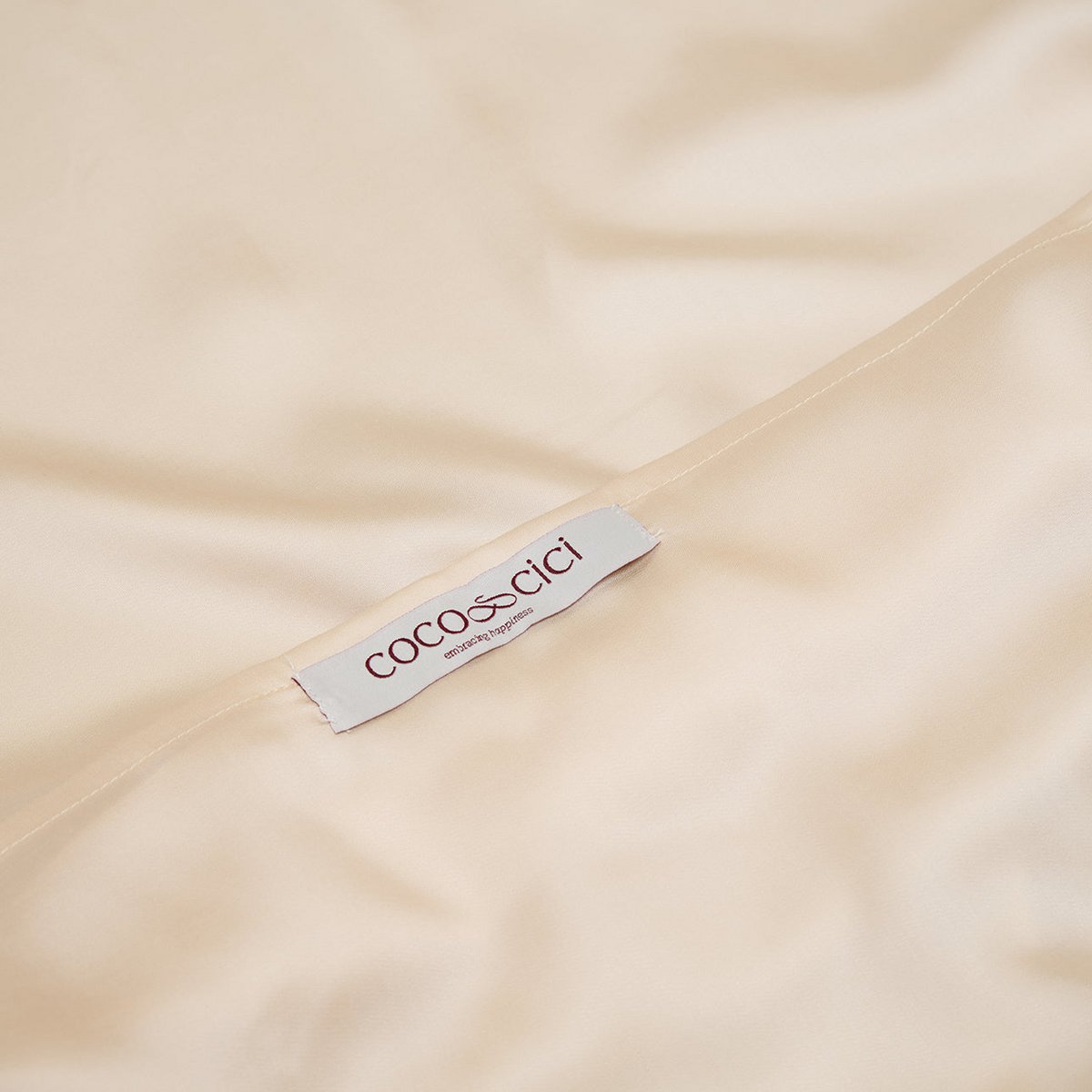 Close-up of the Coco & Cici brand label on the Tencel™ Sateen Pillowcase in White Sand