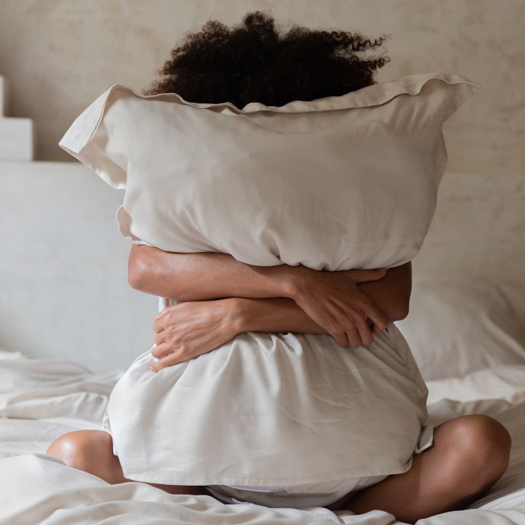 Person hugging a pillow in the Tencel™ Twill Duvet Cover set in Beige