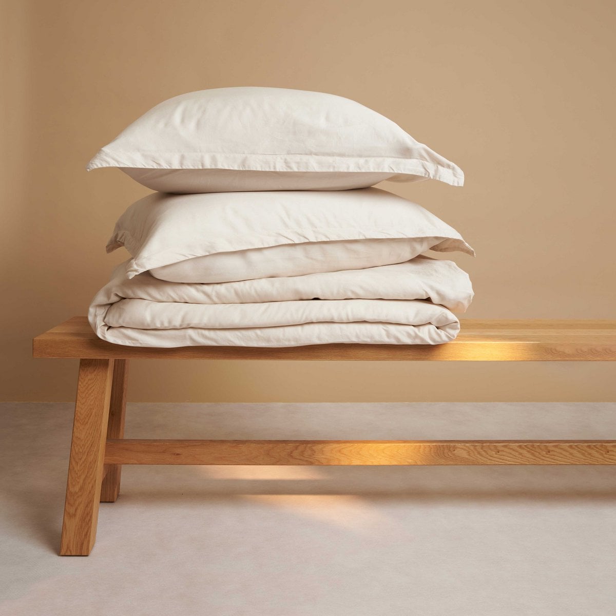 Tencel™ Twill Duvet Cover and pillow in Beige on a wooden bed frame