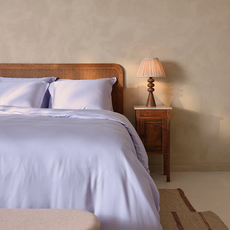 Tencel™ Twill Duvet Cover in Lavender Blue styled on a bed with a wall lamp