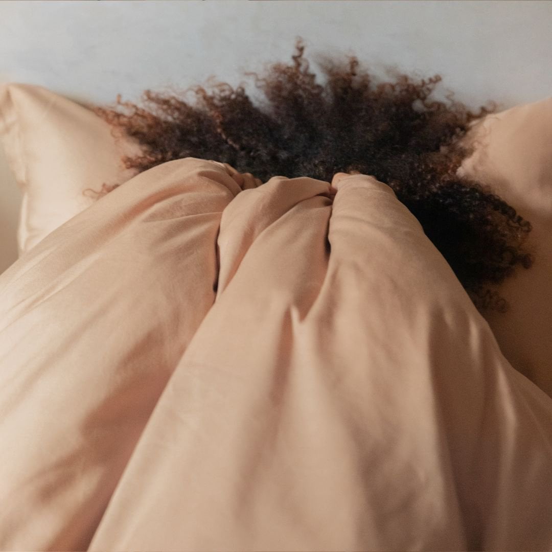 Close-up of a fluffy pillow in the Tencel™ Twill Duvet Cover set, Peach