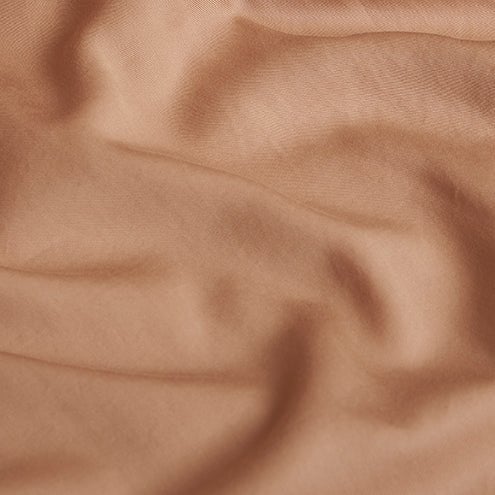 Close-up of the Tencel™ Twill fabric draped, showing texture in Peach