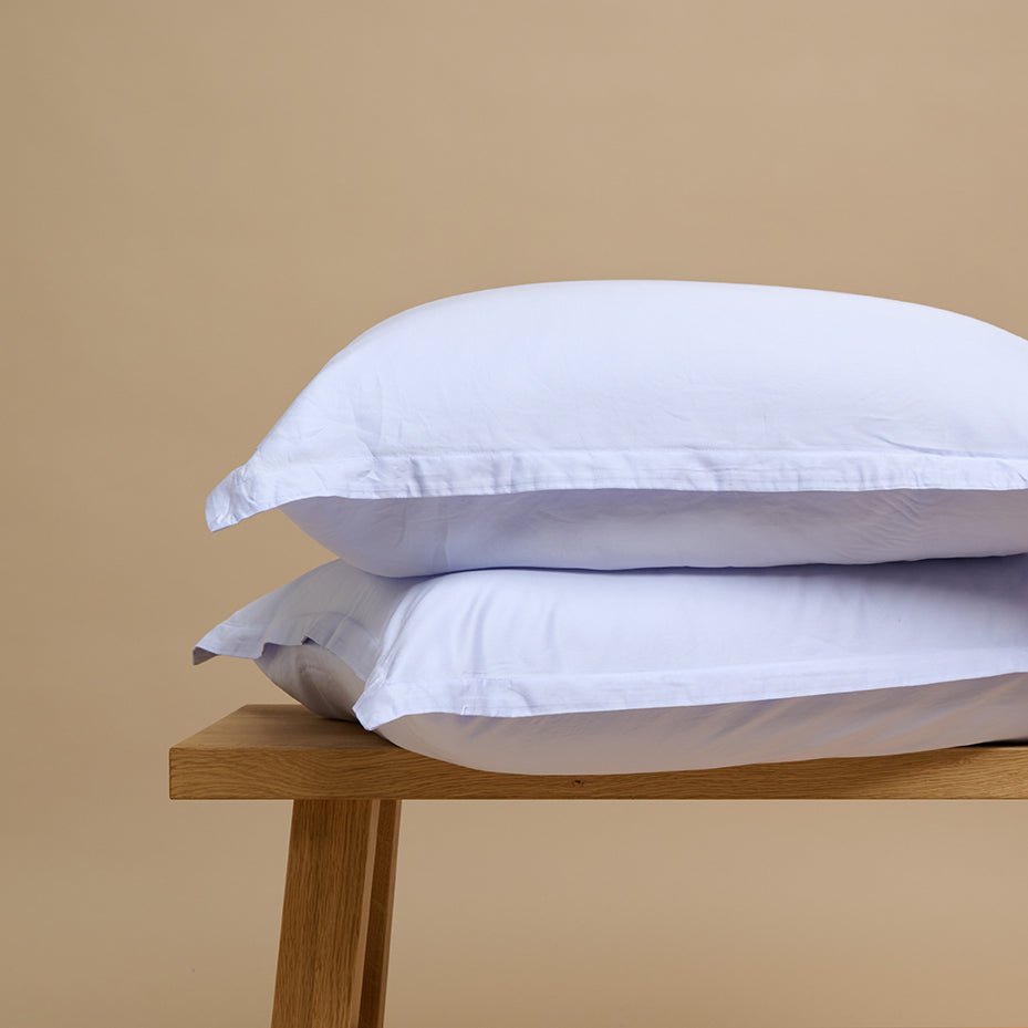 Tencel™ Twill Pillowcase in Lavender Blue stacked on a wooden bench
