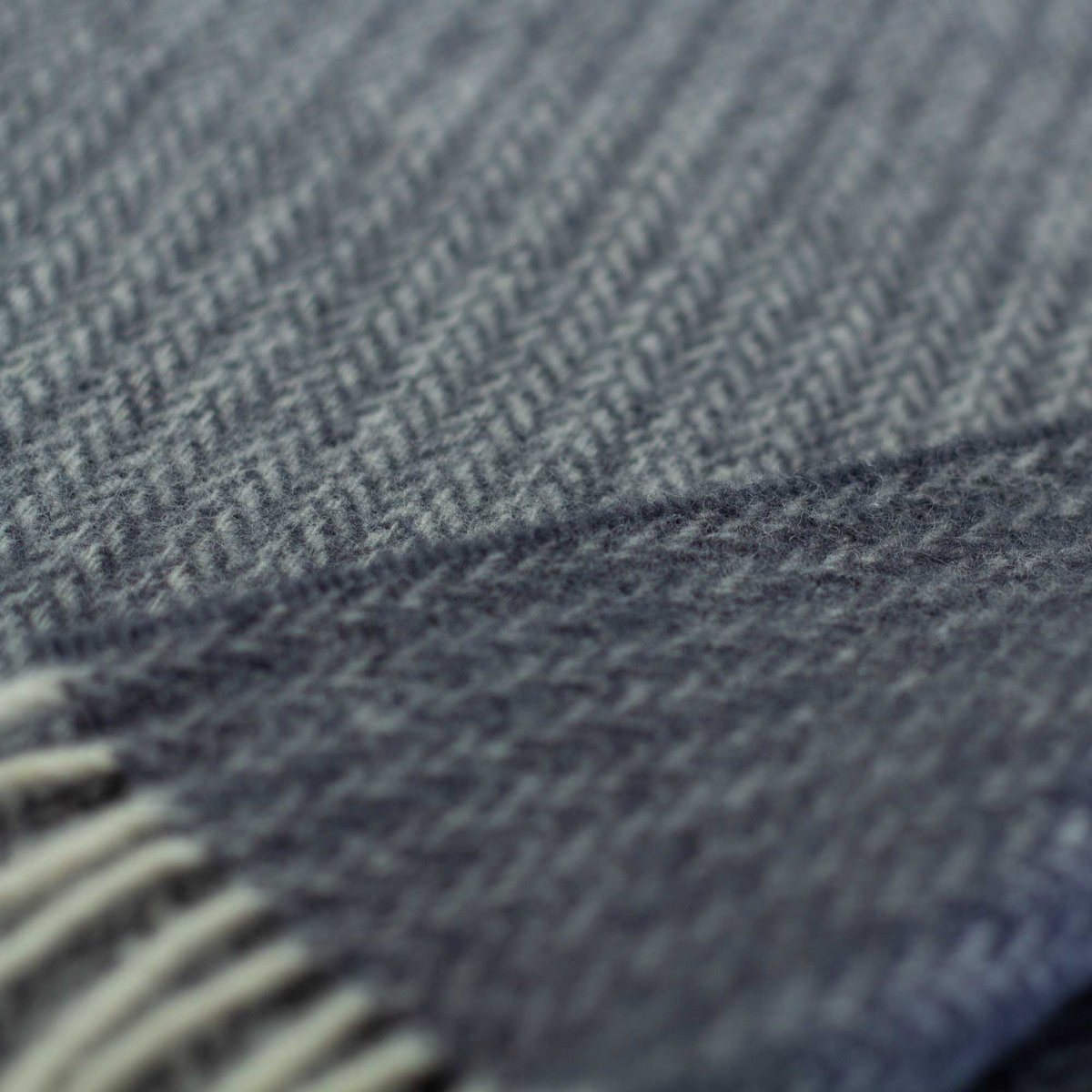 Close-up of Sienna throw's woven blue wool texture and fringe