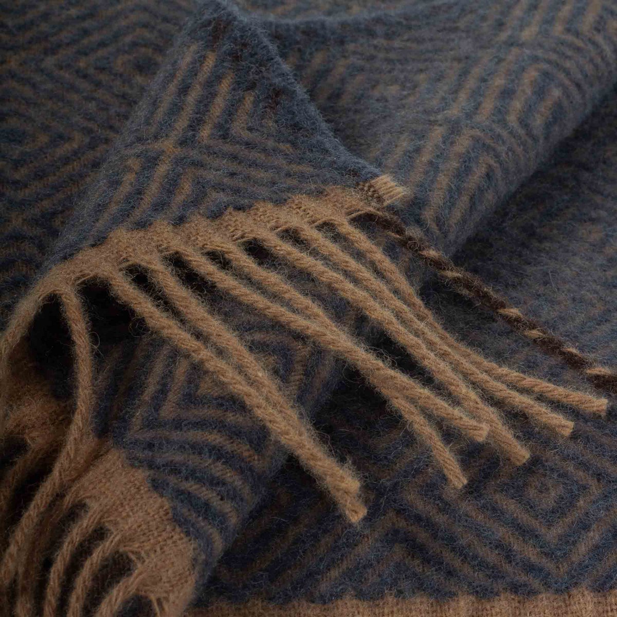 Wool Throw Blanket Venezia in blue diamond weave, draped with fringe detail